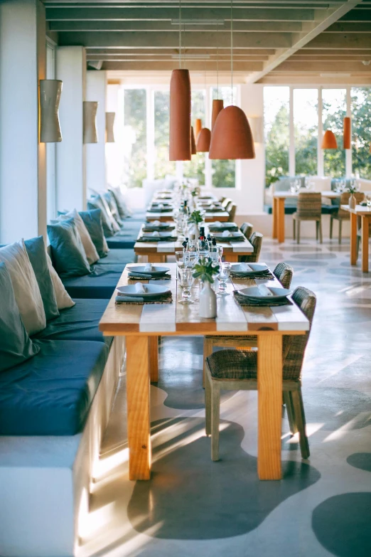 a dining room filled with lots of tables and chairs, unsplash, soft natural lighting, resort, highly relaxed, greek setting