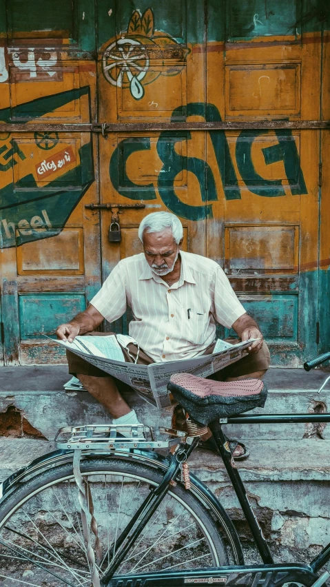 a man sitting on a bike reading a book, pexels contest winner, hyperrealism, old dhaka, looking cute, yellowed with age, newspaper collage