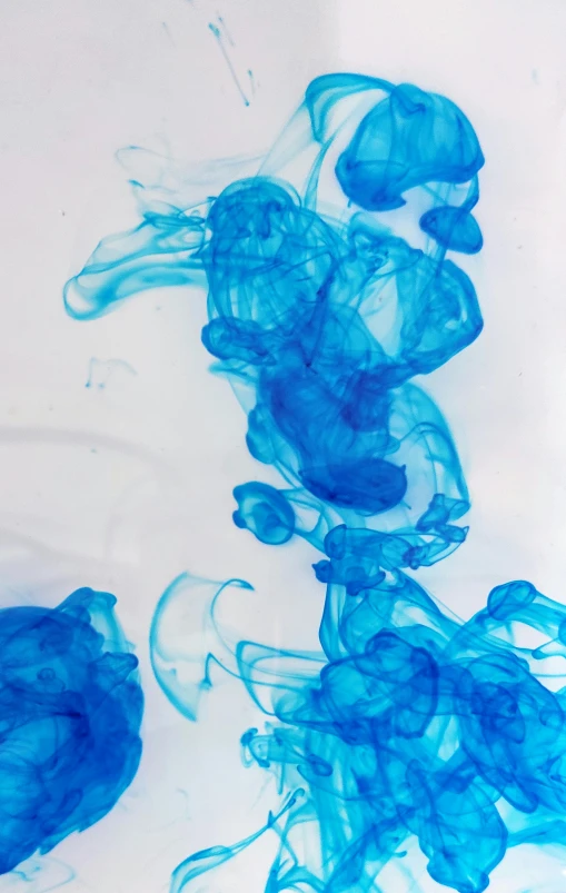 blue ink in water on a white surface, an abstract drawing, unsplash, jelly - like texture. photograph, low quality photo, spores floating in the air, ((blue))