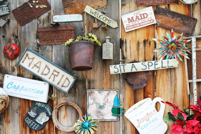 a bunch of signs that are on the side of a building, a picture, by Nancy Spero, unsplash, wood ornaments, found objects, delightful surroundings, on a wooden table