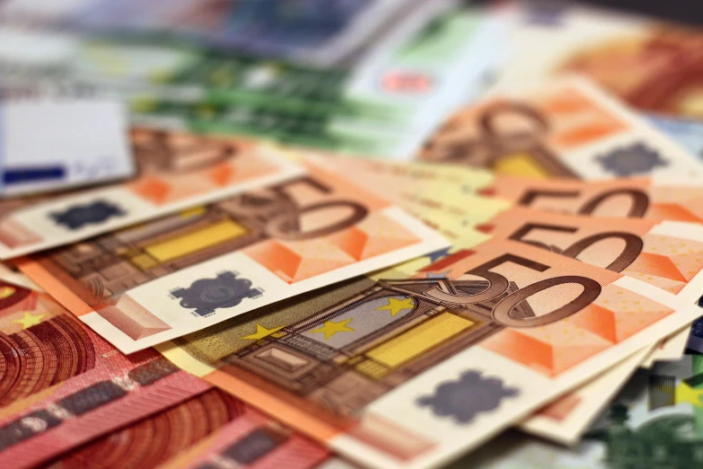 a pile of money sitting on top of a table, full of colours, western european, promo image, thumbnail