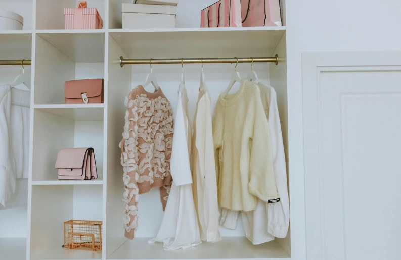 a white closet filled with lots of clothes, a colorized photo, trending on pexels, minimalism, pink and gold color scheme, wearing a white sweater, cottagecore, cream - colored room