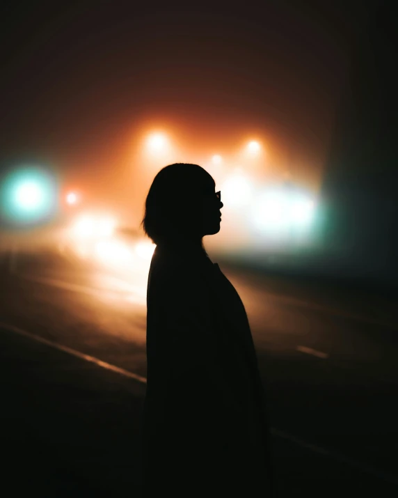 a person standing in the middle of a street at night, profile picture, fog in the background, siluettes, ☁🌪🌙👩🏾