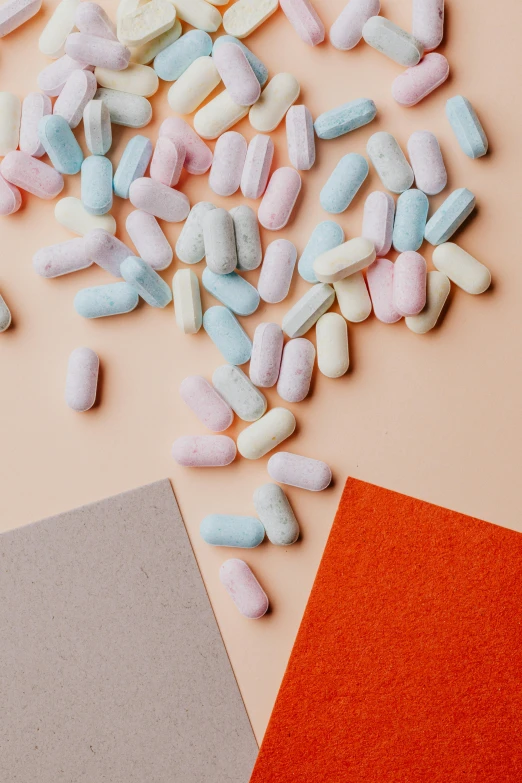 a bunch of pills sitting on top of a table, an album cover, by Anita Malfatti, trending on pexels, color field, orange pastel colors, marshmallows, matte material, pink and blue colors