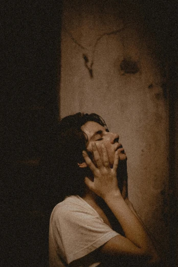 a woman standing in a dark room with her hands on her face, a picture, inspired by Elsa Bleda, trending on pexels, renaissance, a photo of a disheveled man, sweating, beige and dark atmosphere, lo - fi