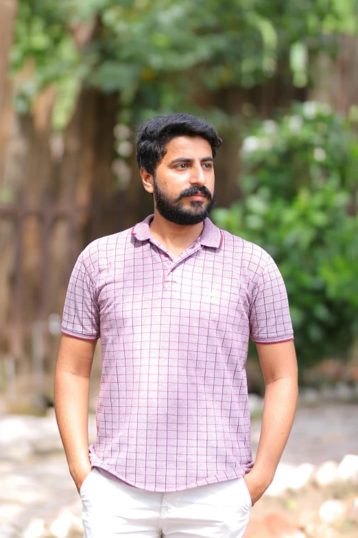 a man standing with his hands in his pockets, a portrait, inspired by Sudip Roy, pexels contest winner, wearing polo shirt, square, bearded, purple