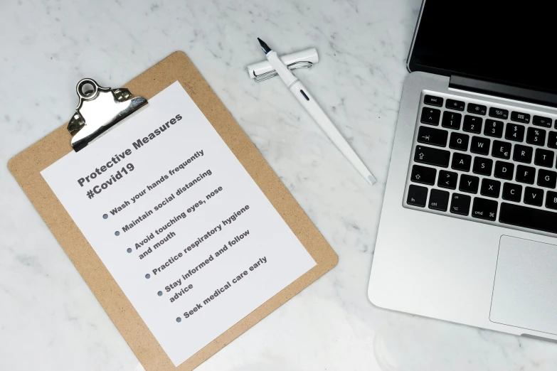 a notepad sitting on top of a desk next to a laptop, by Carey Morris, pexels, private press, medical labels, background image, coronavirus, set against a white background