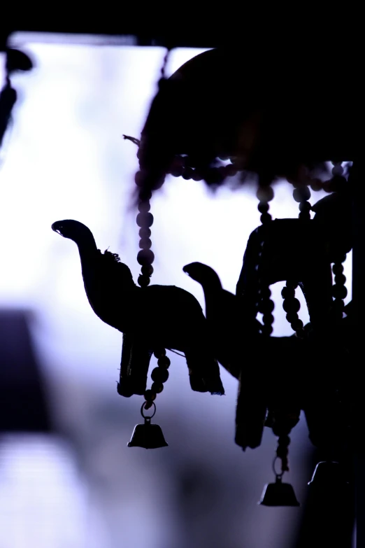 a close up of a person holding a bird, a cartoon, unsplash, sumatraism, beaded curtains, dinosaur, silhouetted, decorations