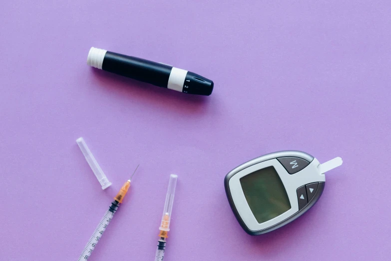 an electronic device sitting on top of a purple surface, syringe, cane, background image, an instrument