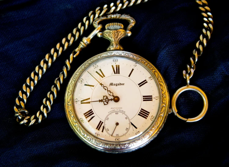 a close up of a pocket watch with a chain, a photo, by Alexander Bogen, happening, miscellaneous objects, blue and white and gold, highly polished, fan favorite