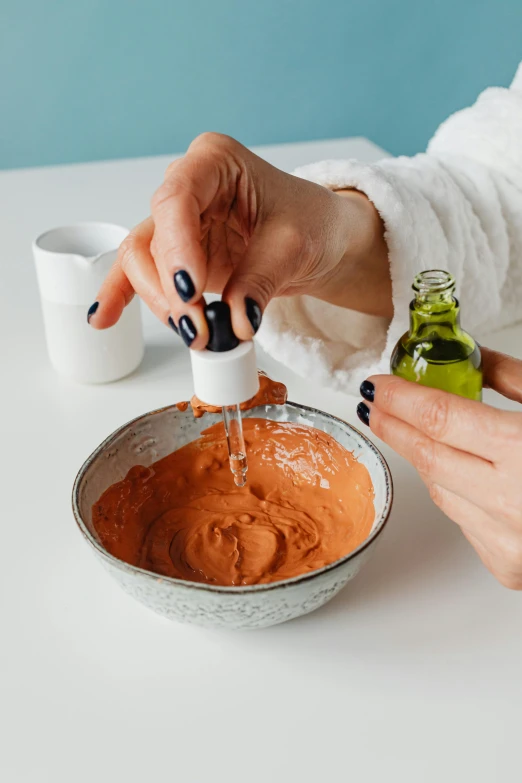 a close up of a person pouring something into a bowl, skincare, red ocher, profile image, ready - made