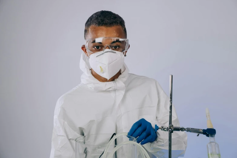 a man in a lab coat holding a test tube, pexels contest winner, off-white plated armor, dust mask, white wall coloured workshop, avatar image