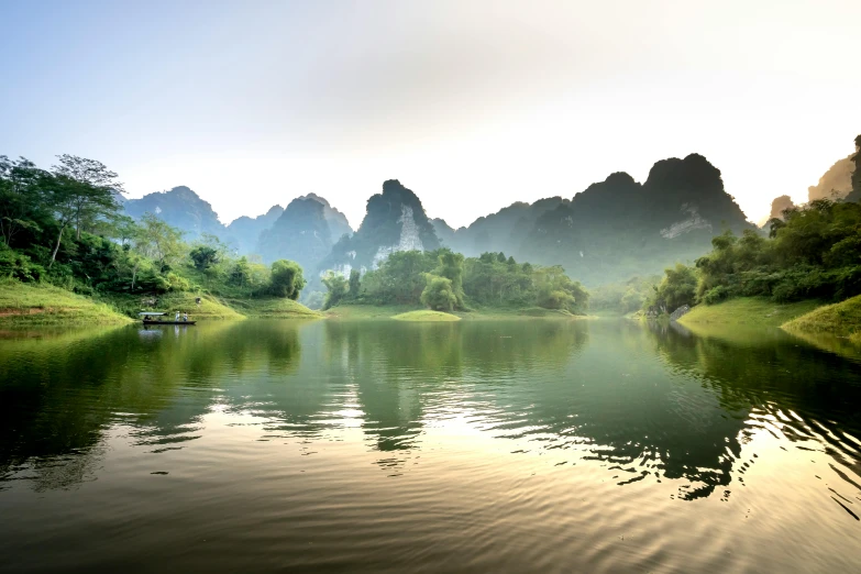 a body of water with mountains in the background, by Reuben Tam, pexels contest winner, romanticism, vietnam, lush valley, soft morning light, floating chinese lampoons