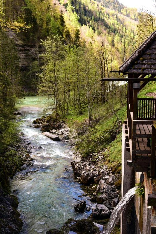 a wooden structure sitting next to a river, a picture, inspired by Peter Zumthor, pexels contest winner, renaissance, lush valley, slovenian, spring evening, rapids