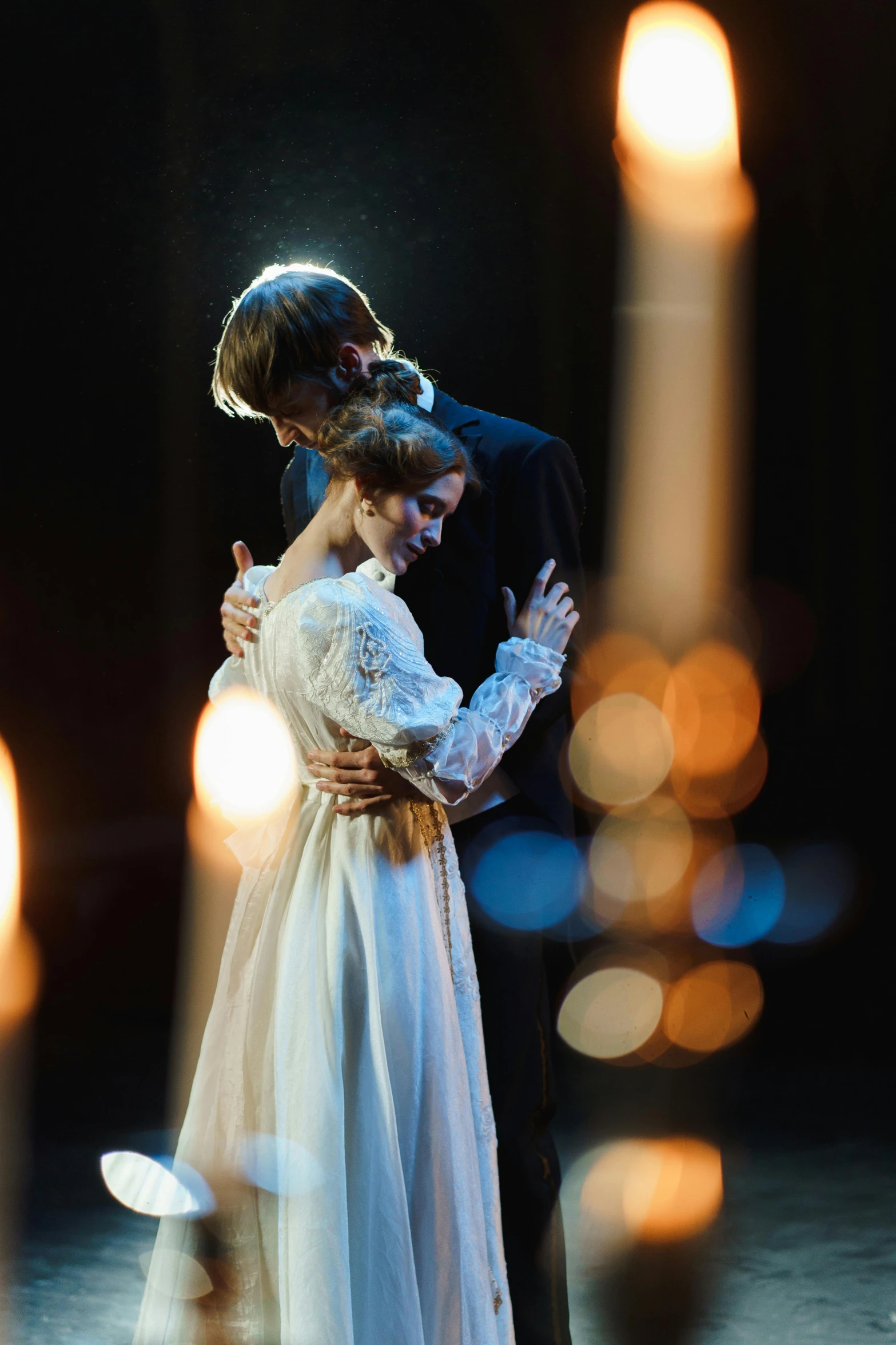 a bride and groom embracing in front of candles, by Elizabeth Polunin, neo-romanticism, 8 k movie still, concert photo, instagram post, press shot