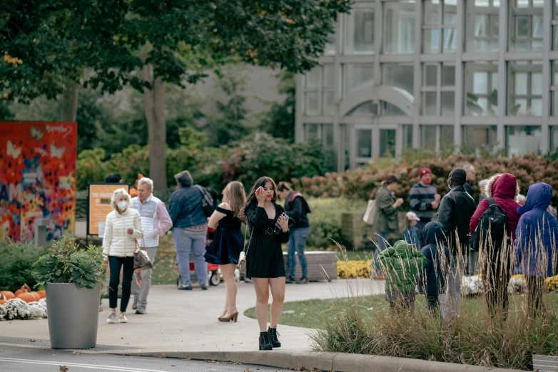 a group of people walking down a sidewalk, a photo, visual art, cornell, people watching, julia sarda, lush surroundings