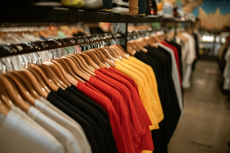 a bunch of shirts hanging on a rack in a store, a photo, by Niko Henrichon, trending on pexels, renaissance, wearing red and yellow clothes, 🦩🪐🐞👩🏻🦳, wearing a t-shirt, white and black clothing