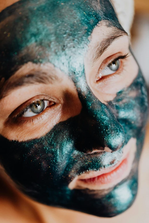 a close up of a person with a face mask, by Julia Pishtar, trending on pexels, lustrous minerals, black blue green, having a good time, face and body