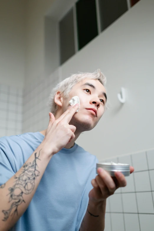 a man shaving his face in a bathroom, a photo, wearing silver hair, non-binary, profile image, asian male