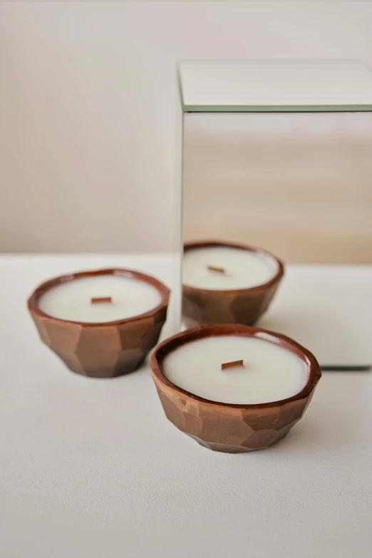 three small candles sitting on top of a table, hand glazed pottery shards, rose gold, wooden bowl, ffffound