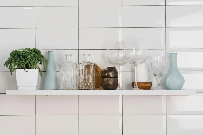 a shelf with vases and glasses on it, unsplash, made of all white ceramic tiles, in a kitchen, panorama shot, medium head to shoulder shot