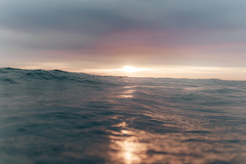 a person riding a surfboard on top of a wave, unsplash, minimalism, looking out at a sunset, wet surface, blurred, instagram photo