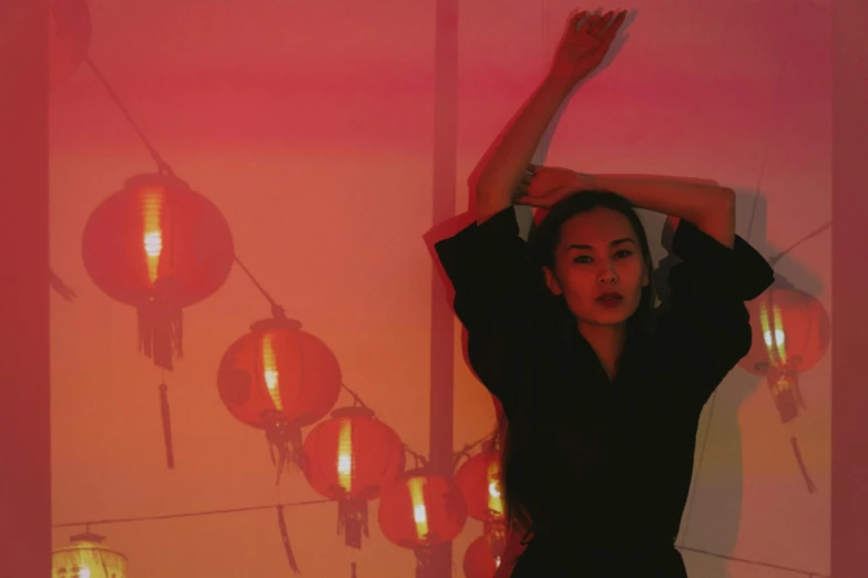 a woman that is standing in front of a mirror, an album cover, inspired by Li Di, chinese lanterns, soft red lights, with arms up, catalog photo