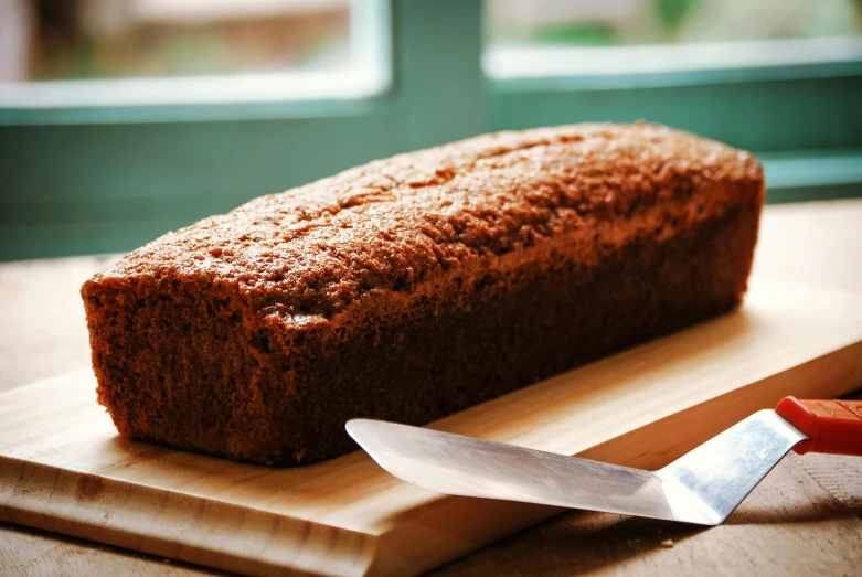 a loaf of bread sitting on top of a cutting board, inspired by Richmond Barthé, unsplash, hurufiyya, cake, square, panoramic, with a long