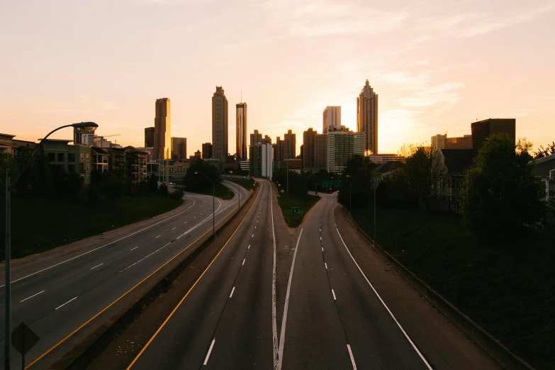 a highway with a city skyline in the background, by Carey Morris, pexels contest winner, hurufiyya, drone footage, at dawn, instagram post, cinematic shot ar 9:16 -n 6 -g