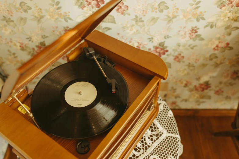 a record player sitting on top of a wooden table, an album cover, by Elsa Bleda, trending on pexels, arts and crafts movement, 1 9 2 0 s room, an intricate, an old, come on