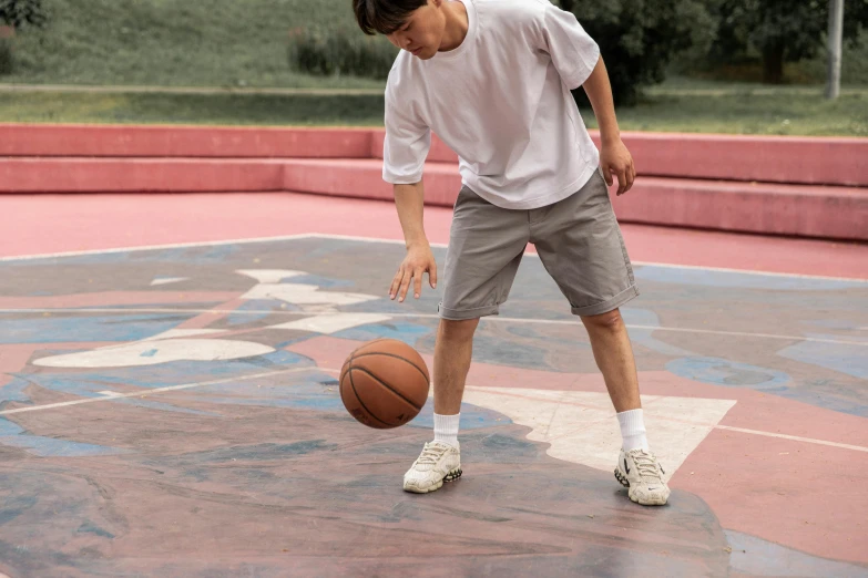 a young man dribbling a basketball on a court, by Gavin Hamilton, trending on dribble, cargo shorts, grey, terrazzo, family friendly