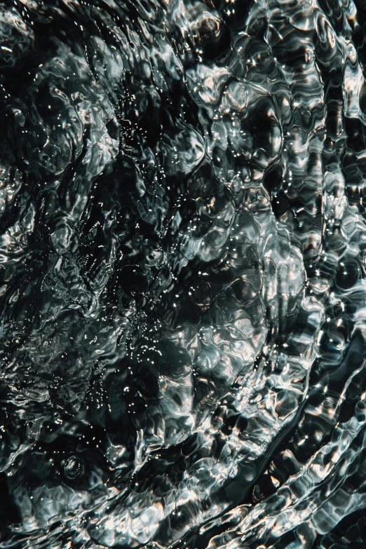 a close up of a black and white photo of water, inspired by Vija Celmins, unsplash, conceptual art, hyper - detailed color photo, made of liquid metal, alessio albi, black and silver