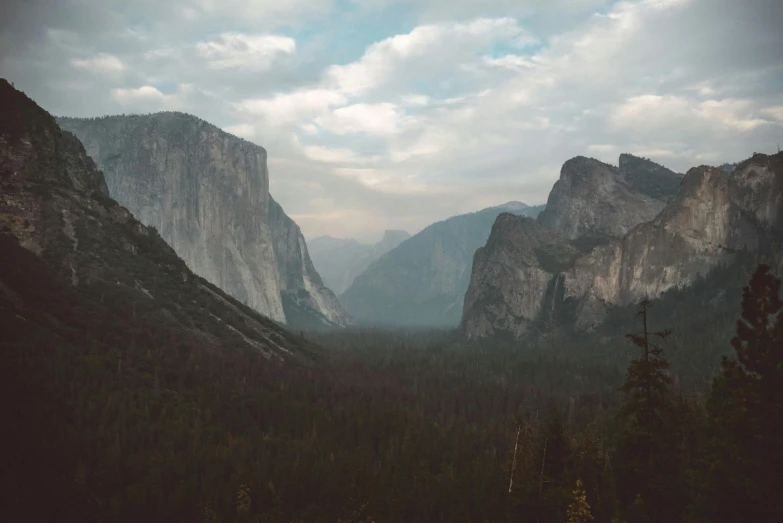 a view of a valley with mountains in the background, unsplash contest winner, visual art, el capitan, grey forest background, early evening, 4 k hd wallpapear