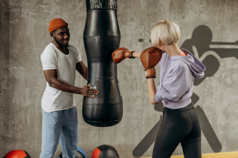 a man and a woman standing in front of a punching bag, pexels contest winner, 🤬 🤮 💕 🎀, thumbnail, background image, working out