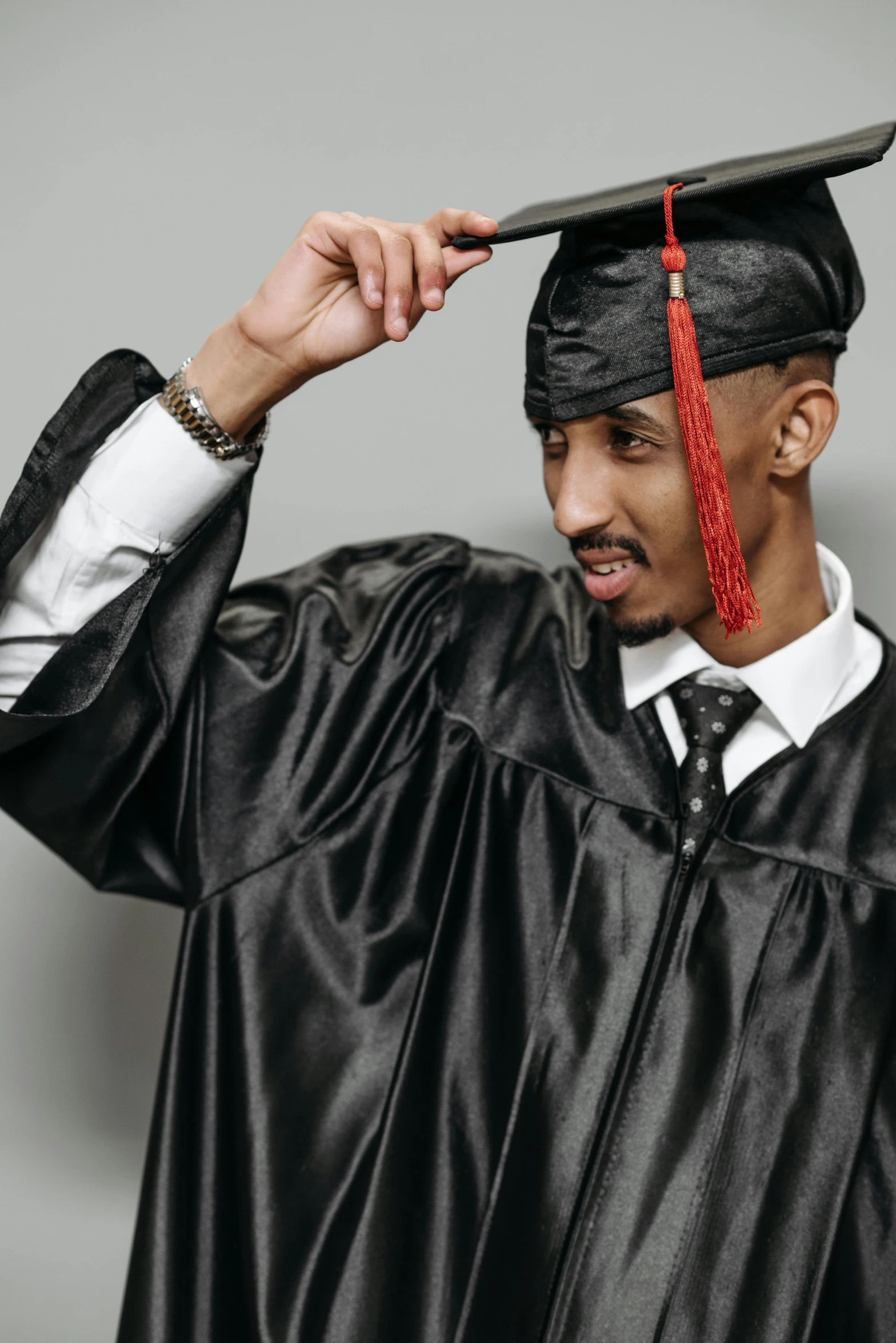 a man in a graduation gown adjusts his cap, by Ben Zoeller, tupac, ashteroth, digital photo, tassels