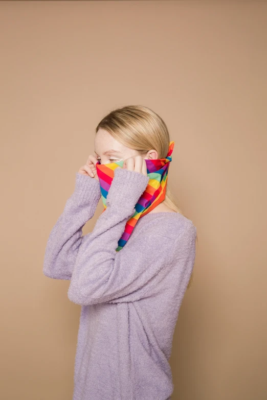 a woman covering her face with a colorful scarf, inspired by Okuda Gensō, wearing turtleneck, broken rainbow, medium - shot, product shot