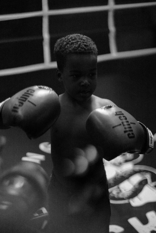 a black and white photo of a boy in a boxing ring, inspired by Gordon Parks, happening, ffffound, afro tech, 4yr old, human fighter