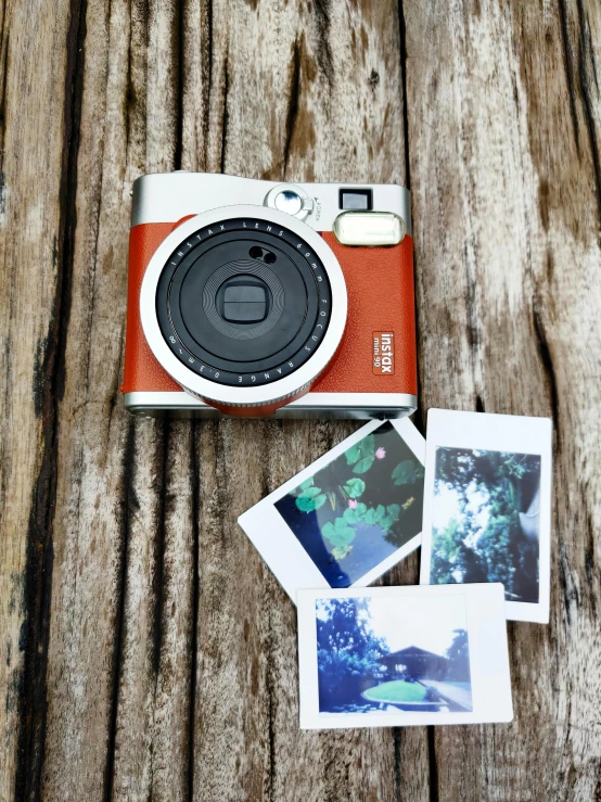 an orange camera sitting on top of a wooden table, a polaroid photo, 2 5 6 x 2 5 6 pixels, fujifilm x100v, with vegetation, medium wide front shot