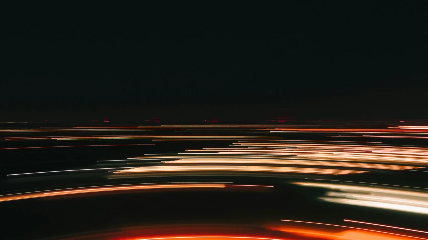 an airplane flying over a city at night, a picture, by Emma Andijewska, unsplash, speed lines, abstract, headlights, time - lapse