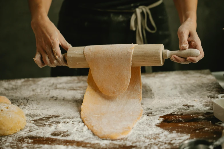 a person rolling out dough with a rolling pin, inspired by Michelangelo Buonarotti, trending on pexels, flowing ginger hair, ribbon, thumbnail, chef table