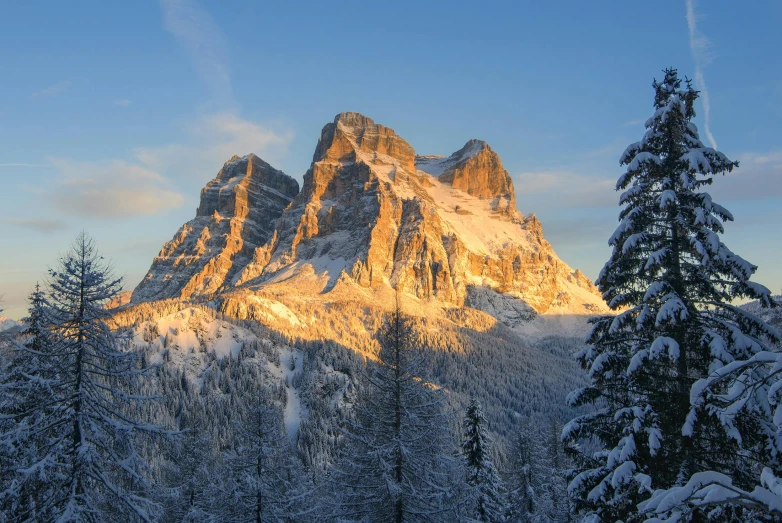 a snow covered mountain with pine trees in the foreground, by Sebastian Spreng, pexels contest winner, golden hour lighing, dolomites in the background, avatar image, conde nast traveler photo