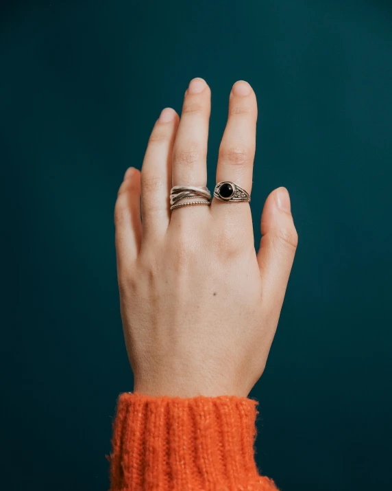 a woman's hand with a ring on her finger, inspired by L. A. Ring, trending on unsplash, renaissance, high detail product photo, dark colours, square, intertwined