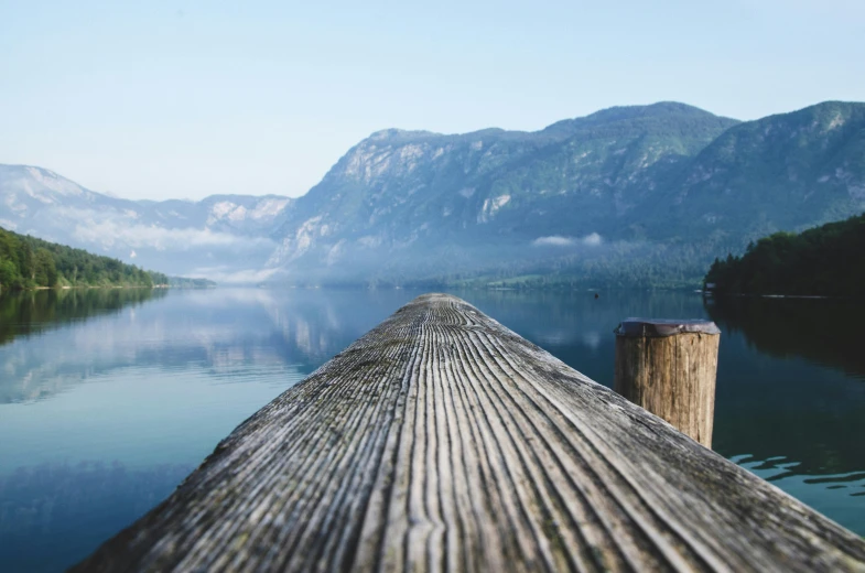 a dock on a lake with mountains in the background, by Sebastian Spreng, visual art, looking across the shoulder, wood, manifestation, conde nast traveler photo