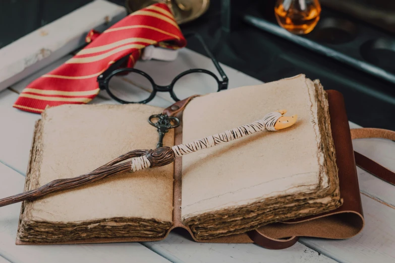 an open book sitting on top of a table, inspired by Hermione Hammond, trending on pexels, long trunk holding a wand, handmade, thumbnail, a list cast