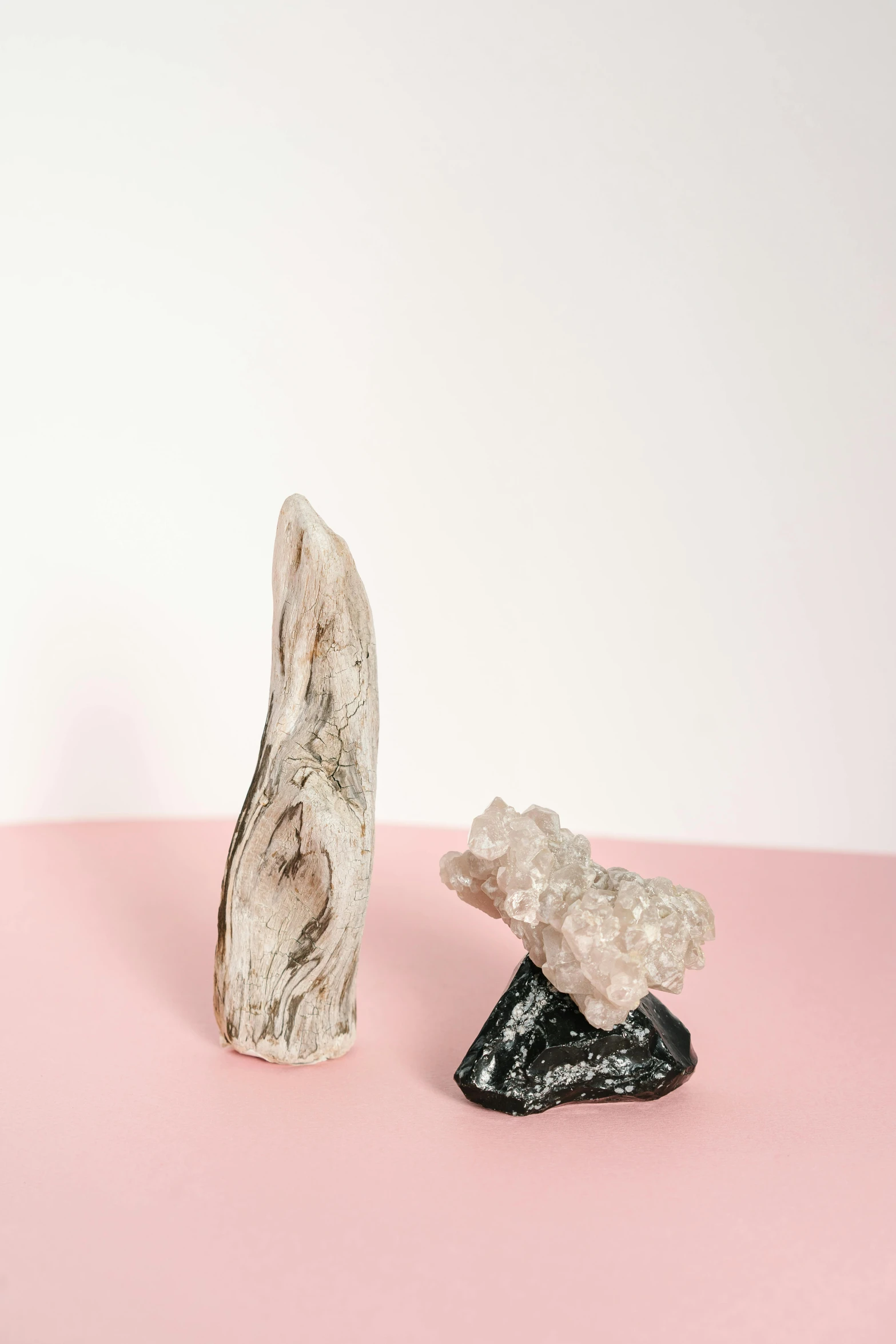 a couple of rocks sitting on top of a pink surface, an abstract sculpture, by Rachel Reckitt, bone jewellery, made of crystals, detailed product image, tall shot