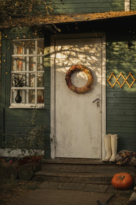 a green house with a wreath on the front door, pexels contest winner, folk art, golden hues, cosy atmosphere, brown, lookbook