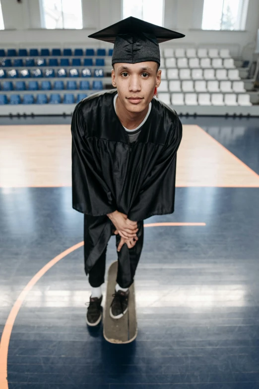 a young man sitting on top of a basketball court, featured on dribble, antipodeans, dressed as a judge's robes, non binary model, wearing black clothes, wingspan style