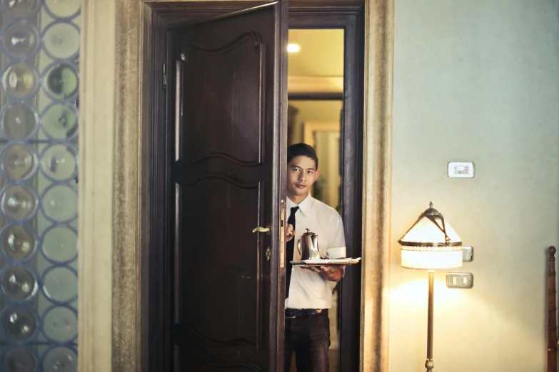 a man that is standing in front of a door, hotel room, in house