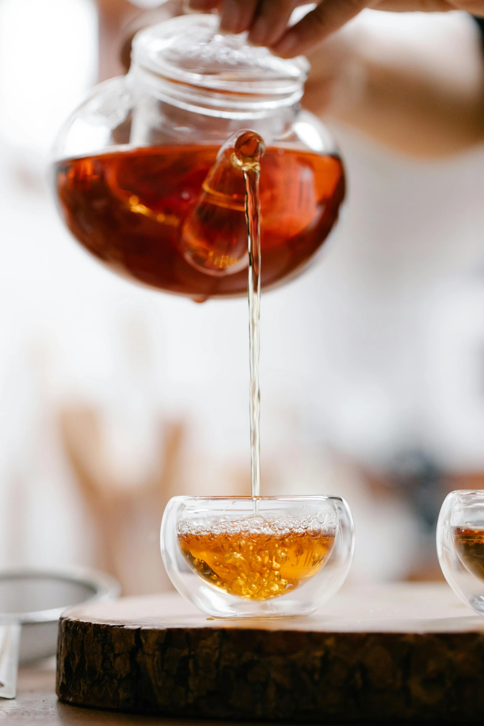 a person pouring tea into two cups, trending on pexels, liquid translucent amber, flawless structure, zoomed in, pot