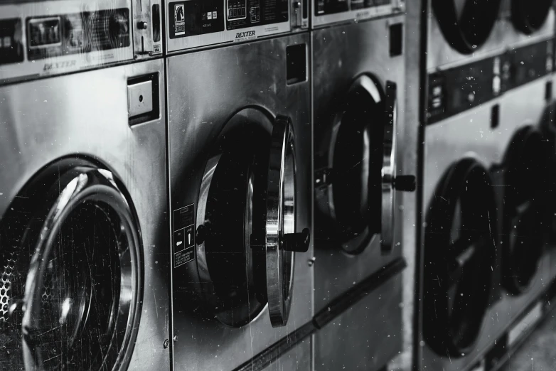 a black and white photo of a row of washing machines, pexels contest winner, brown, shiny metal, cinematic, snapchat photo